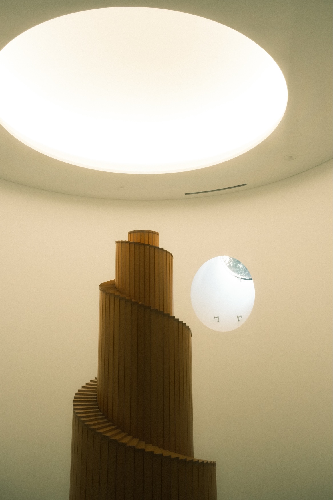 漫射的光線賦予空間一種內斂而神聖的氛圍，讓這個過渡空間昇華為整棟建築令人駐足的場景