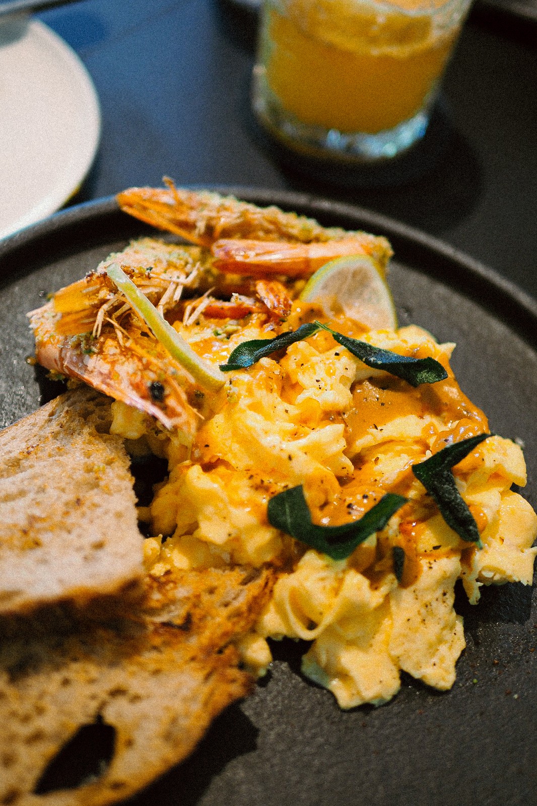 法式蝦醬淋在嫩蛋上，結合鼠尾草香料奶油草蝦、馬告與開心果，讓香氣在細節中層層展開